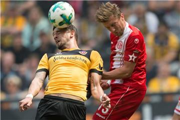 Augen zu und hoch: Kopfballduell zwischen Dynamos Pascal Testroet (l) und dem Düsseldorfer Adam Bodzek. Foto: Sebastian Kahnert