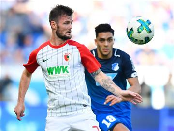 Augsburgs Marcel Heller (l) und Hoffenheims Nadiem Amiri kämpfen um den Ball. Foto: Uwe Anspach