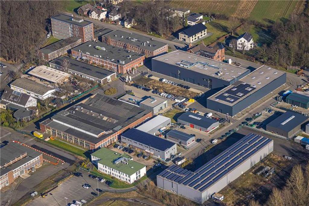 Ex-Caterpillar-Verwaltung HBT: Entweder Flüchtlingsunterkunft oder Hotel Aus dem ehemaligen Caterpillar-Gelände ist der Westfalia-Campus geworden. Der neue Eigentümer Hauhinco will das sechsstöckige Verwaltungsgebäude (hinten links) vermieten.