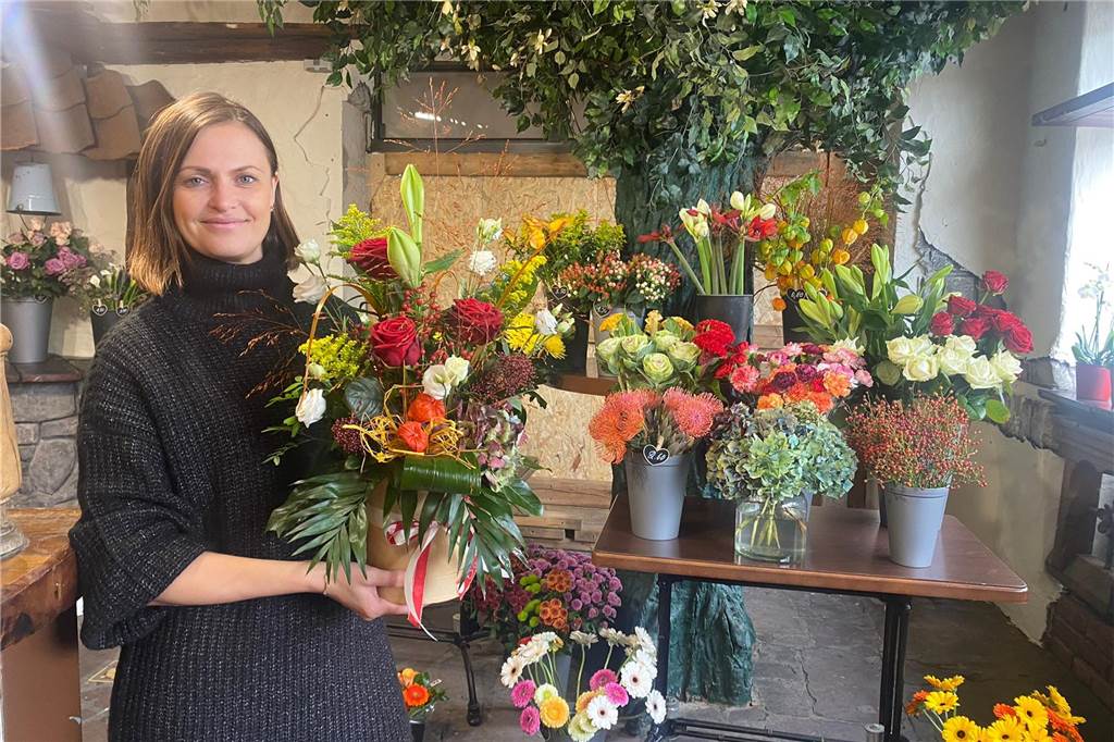 Anastasia Krukov zeigt die Blumen in ihrem neuen Geschäft.