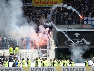 Aus dem Gästeblock beim VfB Stuttgart werden Feuerwerkskörper von KSC-Fans auf das Spielfeld geworfen. Foto: Deniz Calagan