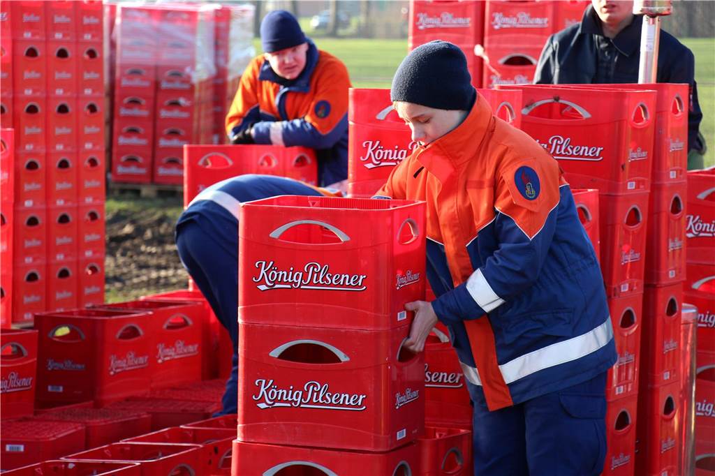 Feuerwehr Feldhausen hält nach zehn Jahren immer noch den Weltrekord Feuerwehrleute mit roten König Pilsener-Bierkisten