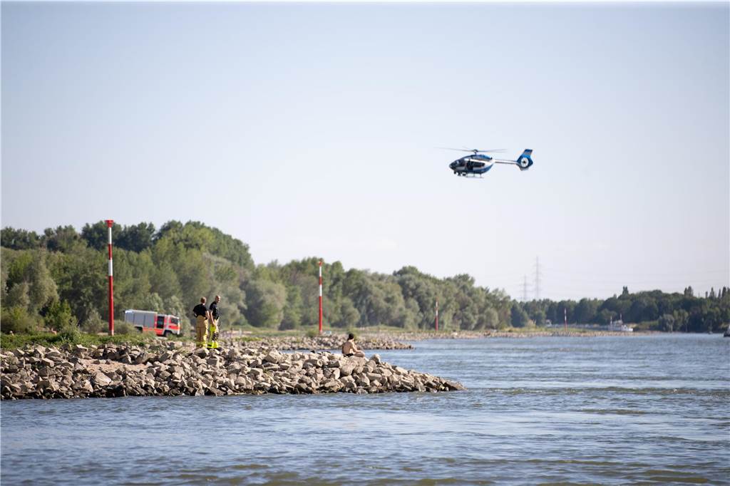 Tödliche Badeunfälle am Wochenende in NRW: Suche nach 22-Jährigem im Rhein Aus einem Hubschrauber und vom Ufer aus suchen Einsatzkräfte nach einem Schwimmer, der im Rheim von einem Sog erfasst und mitgerissen wurde. Ein 22-Jähriger ist am Samstagabend beim Baden im Rhein bei Düsseldorf abgetrieben worden. Nach ihm wurde zunächst erfolglos gesucht, teilte die Polizei am Sonntag mit.