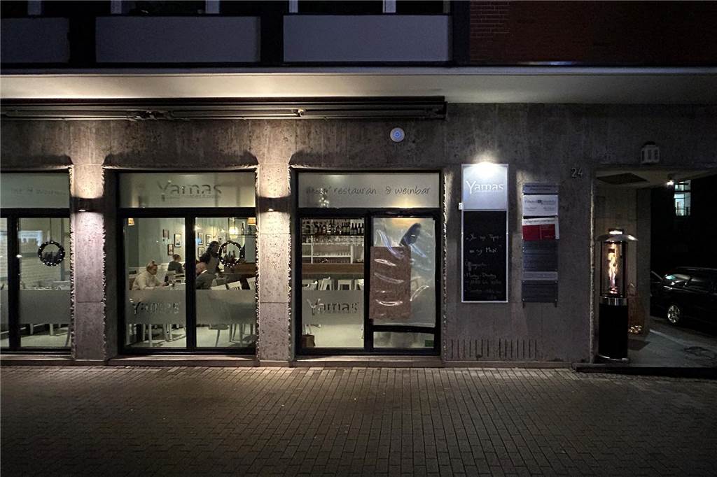 „Traurig, dass das passieren muss“: Das Yamas erlebt zerstörerischen Einbruch Weiter Blick auf die gesamte Außenfront des Yamas. Die Hausfront besteht aus mehreren separaten Fensterscheiben. Eine von ihnen ist nach einem Steinwurf mit durchsichtiger Plastikfolie zugeklebt worden.