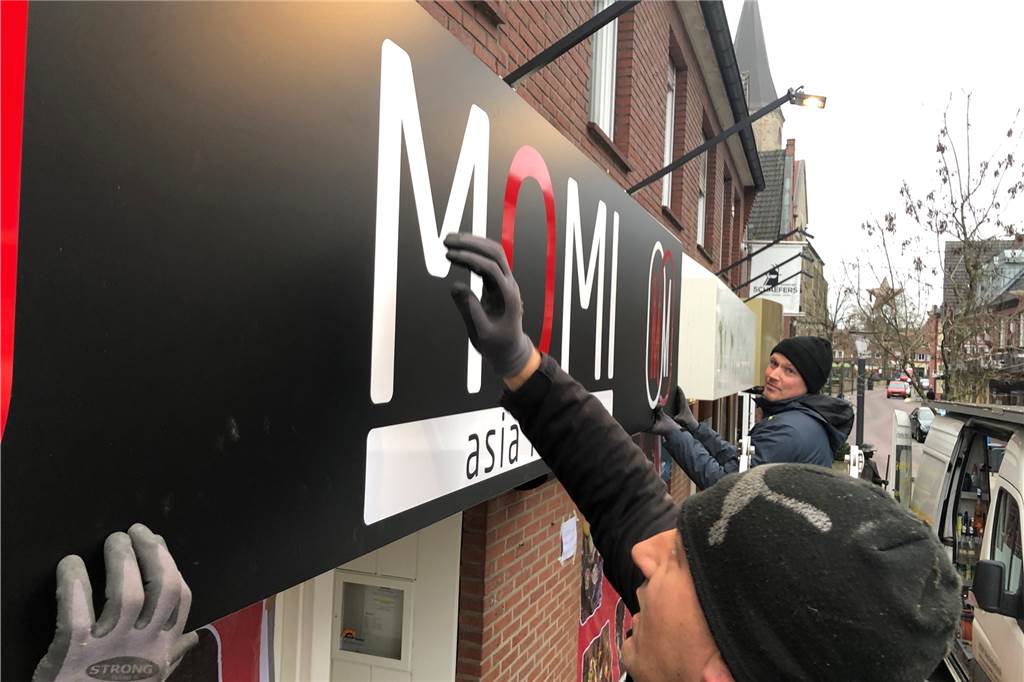 Aus Schaefers Restaurant wird das Momi: Werbetechniker passen an der Dufkampstraße das neue Schild an.