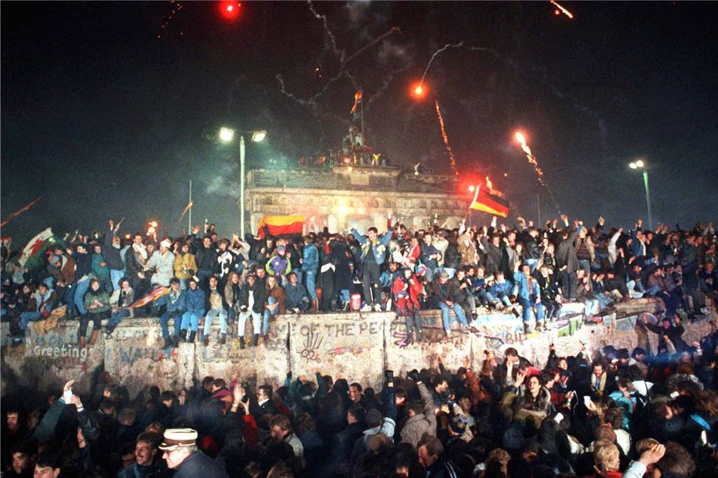 Jahresrückblick 2022: Ein Krieg erschüttert Europa und stellt Solidarität auf die Probe Menschen feiern auf der Berliner Mauer die Wiedervereinigung