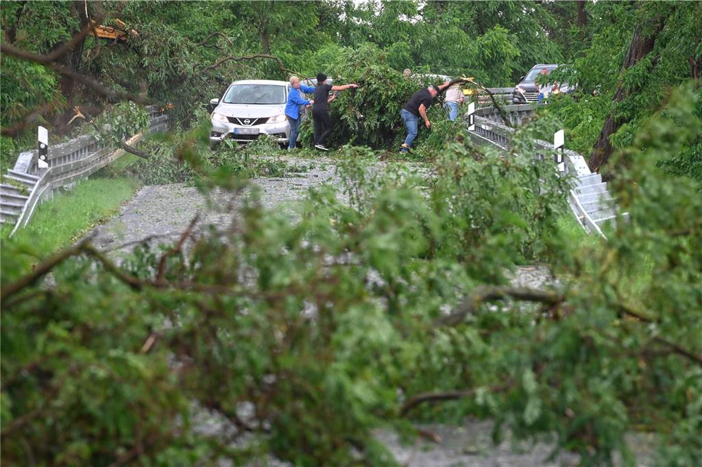 Unwetter über Deutschland: EM-Fanzonen geschlossen und Hurricane-Festival unterbrochen Autofahrer befreien eine Straße von abgeknickten Ästen. Über die Stadt Zörbig im Landkreis Anhalt-Bitterfeld ist eine heftige Gewitterzelle gezogen und richtete zahlreiche Schäden an.