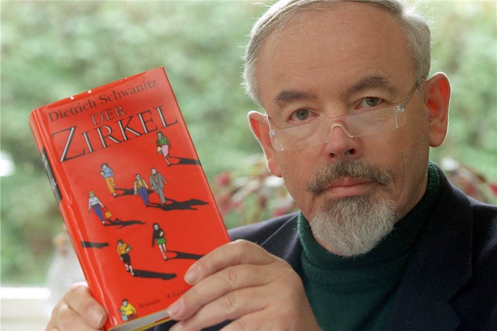 Vier Menschen aus Werne stehen auf der Weltkarte der Promis Dietrich Schwanitz hält eines seiner Bücher in der Hand.