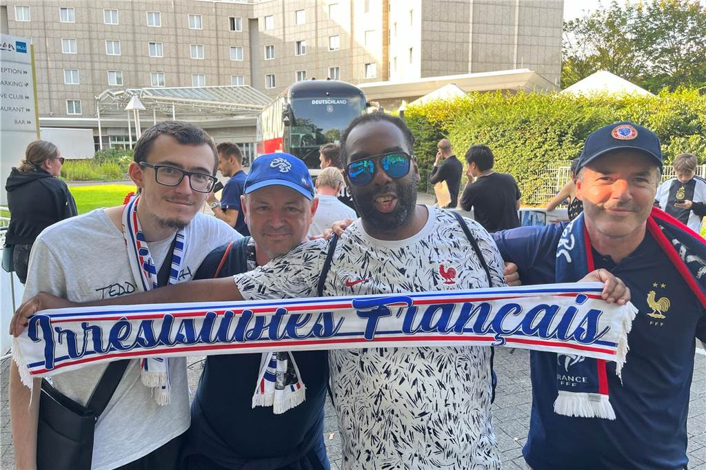 Aymeric, Dennis, Joseph und Franck warten vor dem Hotel auf einen Freund, der dort übernachtet. Die anderen vier sind heute Morgen mit dem Auto aus Paris gekommen und fahren nach dem Spiel auch noch zurück.