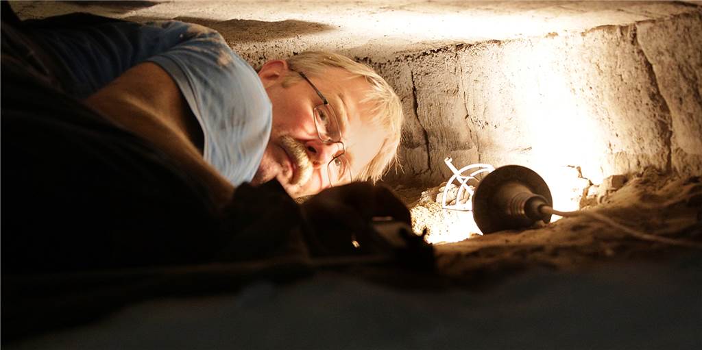 Neue Steine für historischen Backofen bei Balke: Handwerker geben alles Backofenbauer Claus Heuft hat nicht viel Platz beim Arbeiten in der Backofenkammer.