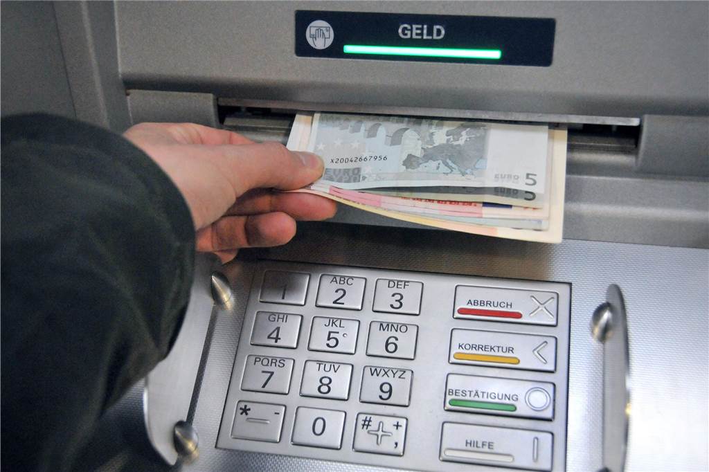 Sparkassen-Entscheidung erhitzt die Gemüter: „Echt zum Kotzen“ An Mann zieht Geld an einem Bankautomaten.