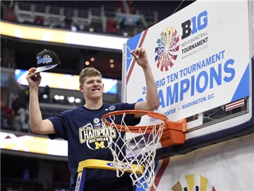 Basketball-Hoffnung Moritz Wagner sichert sich nach dem Sieg gegen die Wisconsin Badgers ein Stück Netz als Trophäe. Foto: Nick Wass