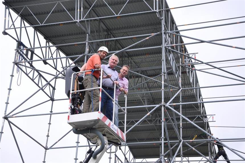 Bühnengerüst wird zum Kletterturm Bauleiter Hajo Müller (l.) zeigt Bezirksbügermeister Hans Semmler und Daniel Binder (Jugendamt Dortmund, v.l.) die Pläne für den Kletterturm vom Kran aus.