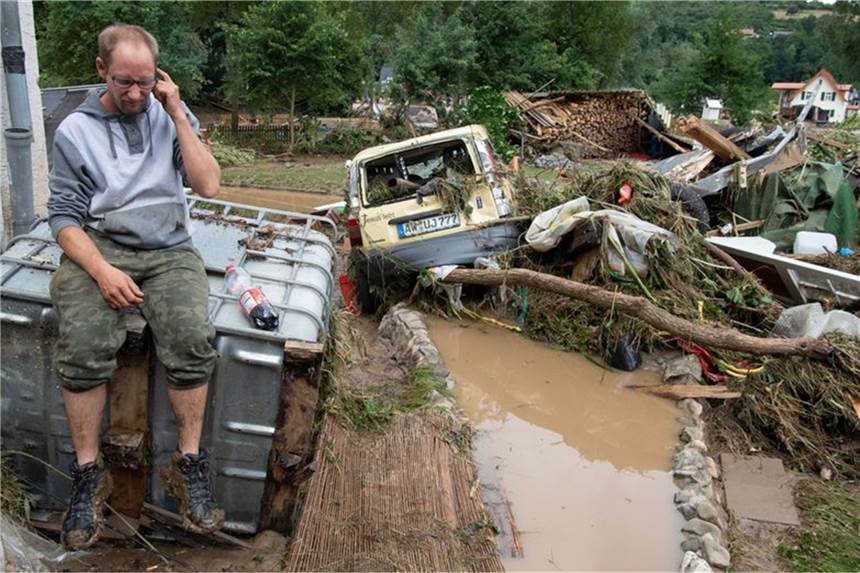 Aufbauen oder gehen? - Zwei Wochen nach der Flut im Ahrtal «Bedeutendstes Foto im ganzen Leben»: Wenige Stunden nach der verheerenden Flutwelle sitzt Daniel Schmitz am Morgen des 15. Juli inmitten eines Trümmerfeldes vor seinem Haus. Foto: Boris Roessler/dpa