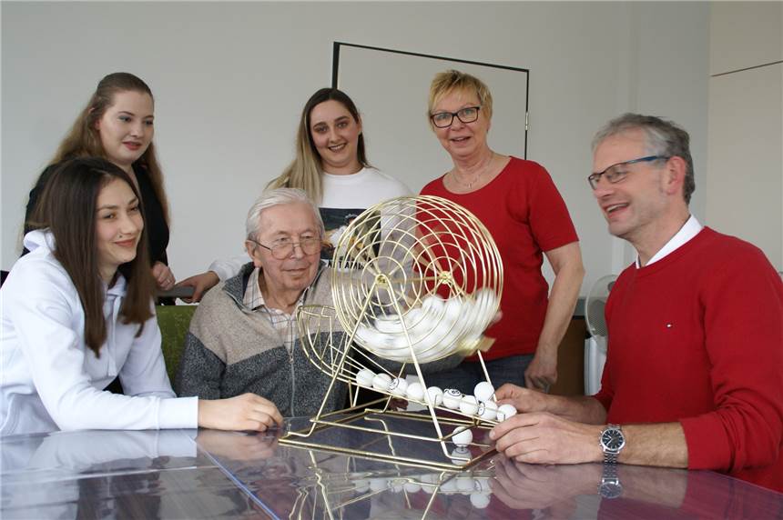 Begegnung im Werkraum der neuen Caritas-Zentrale: Alma (v.l.), Artemisija und Marieta testen mit Karl Kazia (84) schon mal das Bingo-Spiel. Uwe Bröcker (r.) vom Caritasverband Ahaus-Vreden hilft dabei