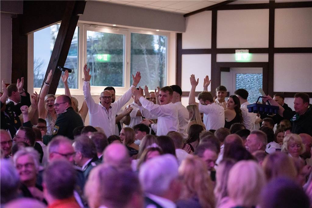 Eine Gruppe Menschen im Festzelt steht auf und jubelt.