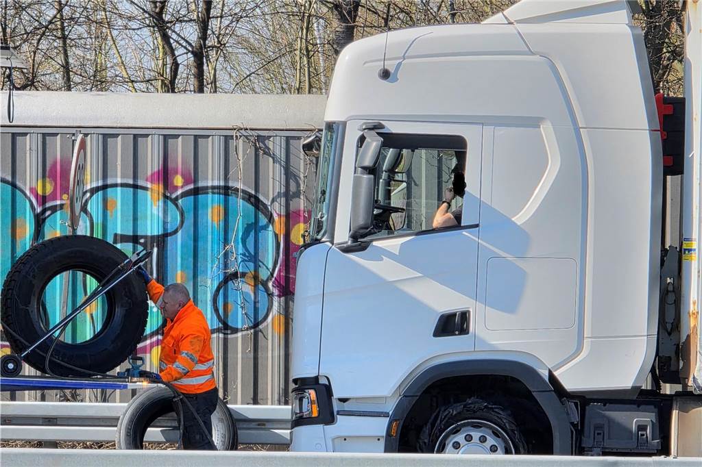 Der Reifen eines LKW wird abtransportiert. 