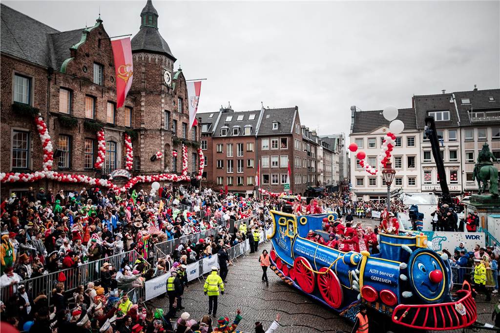 Ein Wagen fährt beim Rosenmontagszug in Düsseldorf am Rathaus vorbei.