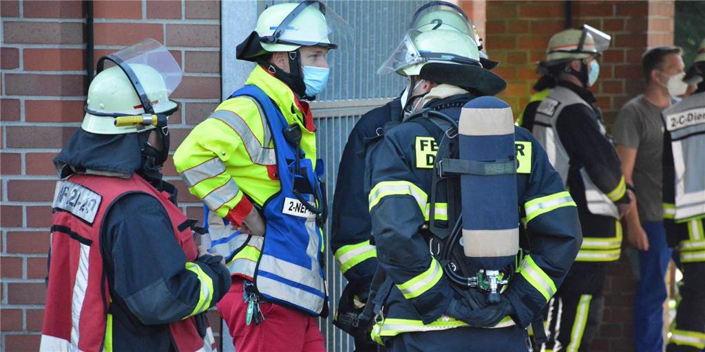 Ungeimpfte Feuerwehrleute dürfen nicht mehr arbeiten – so viele Fälle gibt es in Dortmund Feuerwehrleute unterhalten sich am Rande eines Einsatzes.