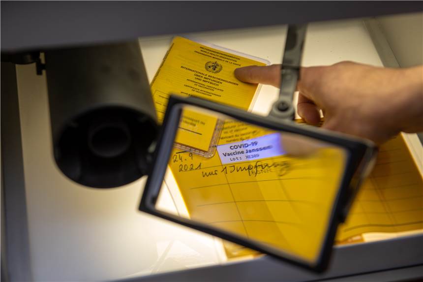 Fälscherwerkstatt für Impfpässe in NRW ausgehoben - 26-Jähriger machte simplen Fehler Bei der Kriminalpolizeiinspektion liegen Impfpässe unter einer Lupe.