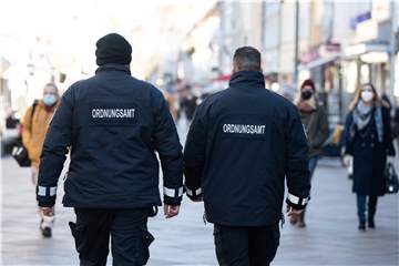 Zwei Mitarbeiter des Ordnungsamtes laufen durch die Straße