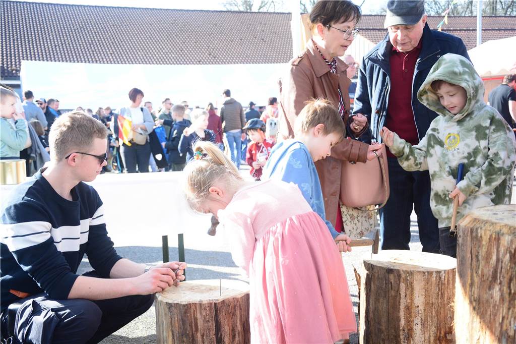 Sandhasensonntag in Alstätte lockt viele Besucher an Ein Mädchen schlägt einen Nagel in einen Holzklotz.