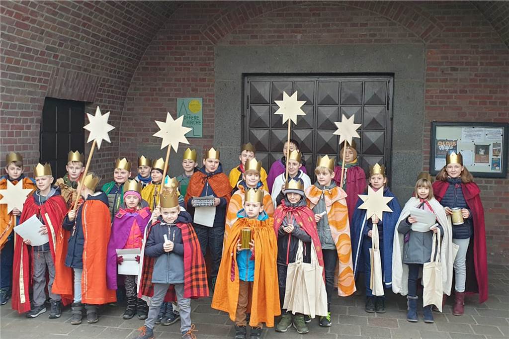 Die Sternsinger im Gewnad vor der Heilig-Kreuz-Kirche