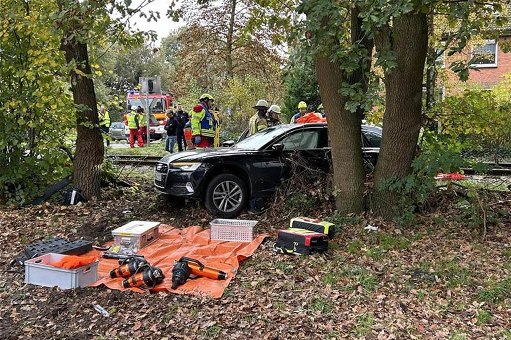 Tobias Cymek (34) arbeitet beim Unfallteam: „Es könnte jeden treffen“ Auf einer orangefarbenen Plane liegen mehrere Werkzeuge. Dahinter steht der kaputte Audi, an dem mehrere Einsatzkräfte der Feuerwehr Lünen stehen.