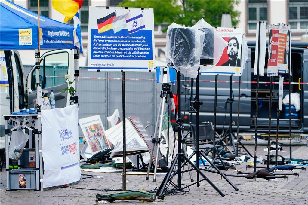Plakate eines Standes liegen auf dem Marktplatz auf dem Boden.