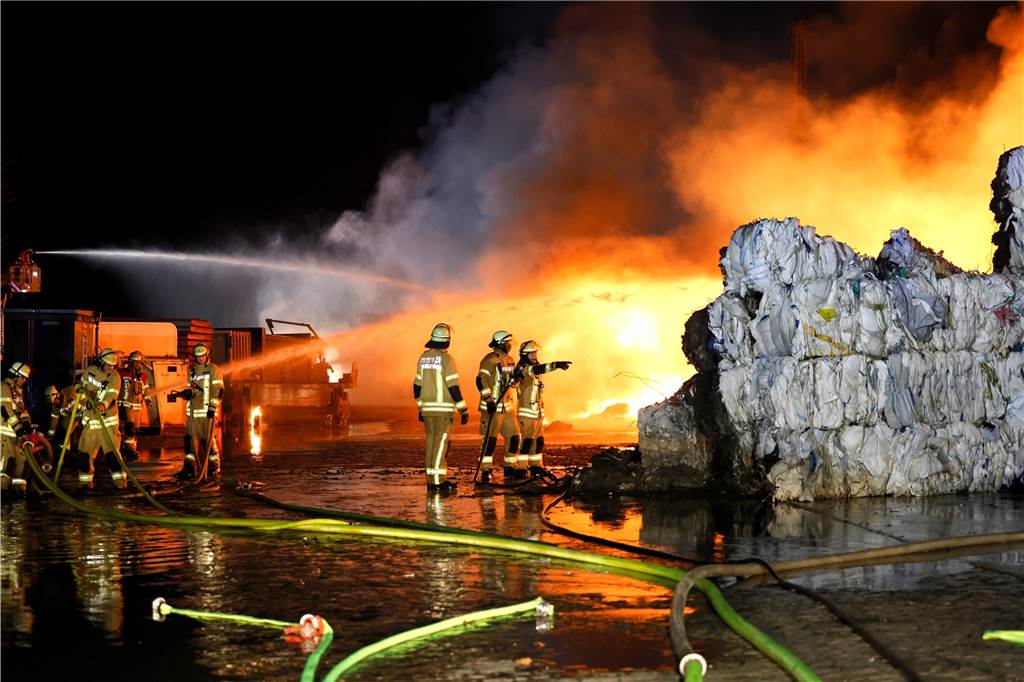 So war die Silvesternacht in NRW : Gewalt in Hagen und Essen, viele friedliche Feiern Feuerwehrleute im Einsatz, im Vordergrund stehen verbrannte Papierrollen.