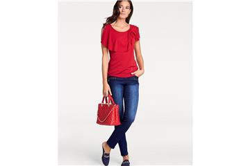 Bei einem kleinen Busen mogeln Volants am Dekolleté - wie bei diesem Top von Heine - mehr Fülle dazu (Blusenshirt ca. 40 Euro, Tasche ca. 180 Euro, Sabots ca. 60 Euro). Foto: Heine/dpa