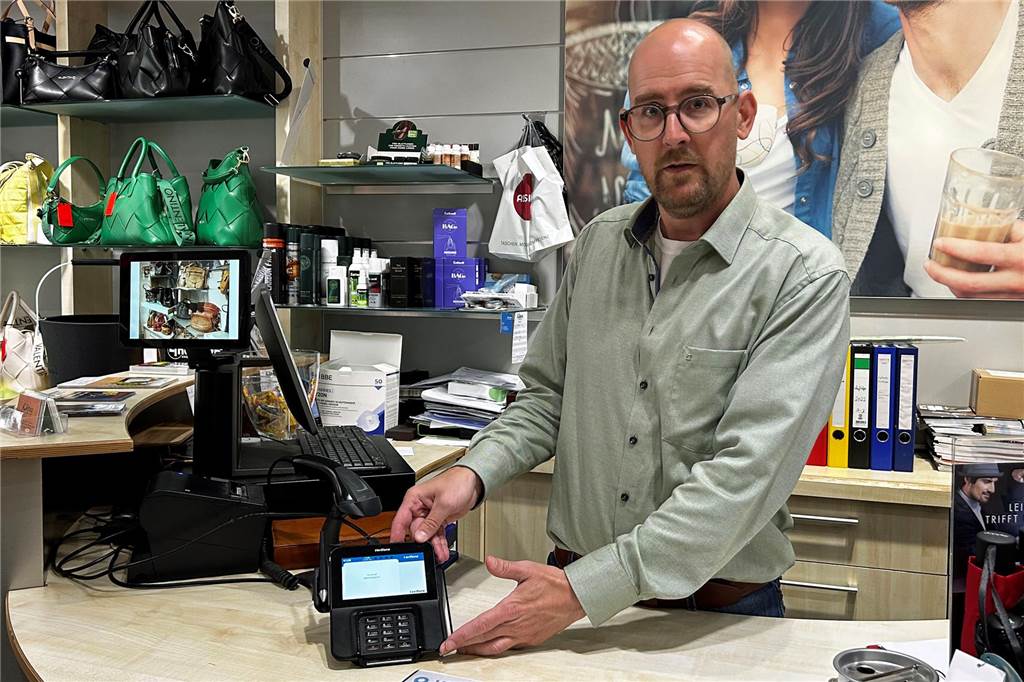 Werne bezahlt mit EC-Karte: Nur wenige Kunden haben noch Bargeld Bei Leder Küper können Kunden dank modernster NFC-Technik ihre Ware sogar via Apple Pay oder durch Auflegen der EC-Karte begleichen. Geschäftsführer Wolfgang Klinge zeigt das entsprechende Gerät.