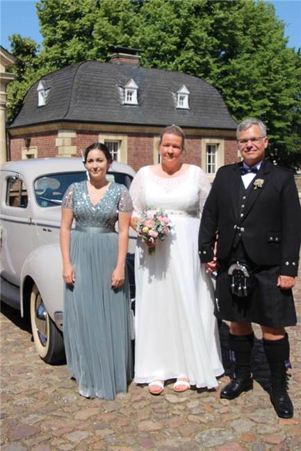 Heiratsantrag auf Halbinsel vor Dublin und Hochzeit im Argyll Kil Das Hochzeitspaar vor einem Oldtimer und der Tochter der Braut vor dem Schloss
