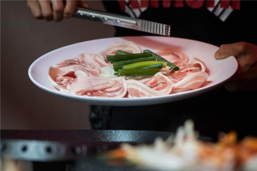Korean Barbecue bringt alle an einen Tisch Beim Barbecue kommen verschiedene Fleischsorten auf den Grill: Typisch ist Schweinebauch. Foto: Franziska Gabbert/dpa-tmn