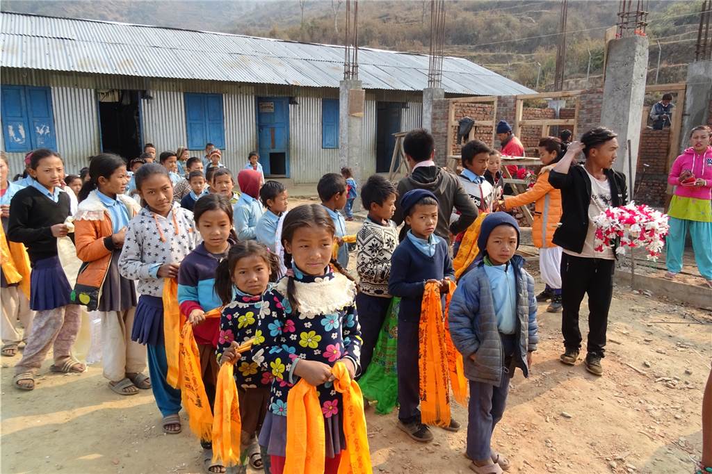 Nach Erdbeben-Katastrophe: Dortmunder Schüler unterstützen Schulaufbau in Nepal Beim Besuch der Schule in Mandra 2018 stand der Holz-Wellblechverschlag noch. Die Schüler aus Dortmund wurden – wie in Nepal üblich – mit farbenfrohen Gebetsschals begrüßt.