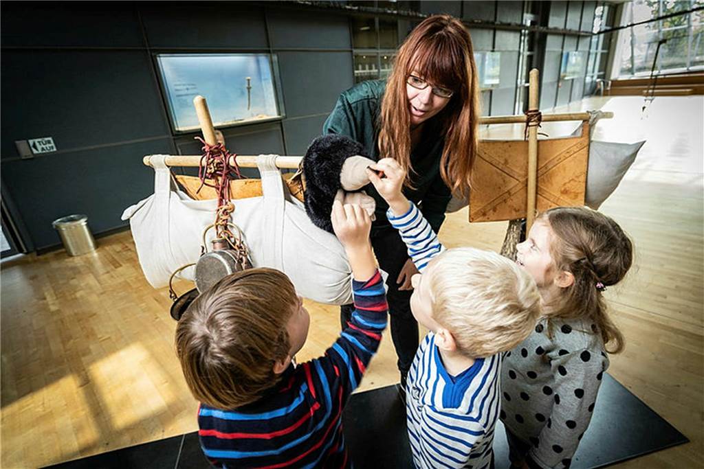 Kinder spielen mit einer Puppe im LWL-Römermuseum in Haltern