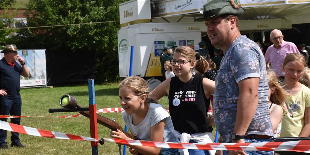 Video und Fotos: Kinder und Schützen haben Spaß auf der Schlingewiese Beim Kinderschützest - eine Ferienspaßaktion - zielten die Kinder mit einem Druckluftgewehr und Tennisbällen auf ein Loch im Holzvogel. Als der dahinter hängende Eimer genügend Bälle gesammelt hatte, kippte sein Gewicht den Vogel um und die Majestät war gefunden.