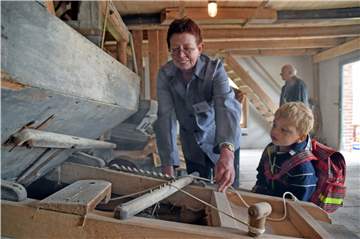 Beim Mühlentag: Maria Menke ist die Müllerin und demonstriert, wie die alte Mühlentechnik funktioniert.