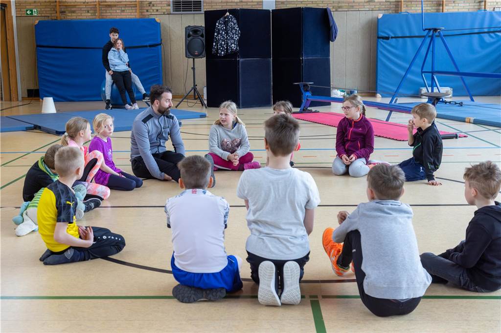 Kinder sitzen in einem Sitzkreis zusammen