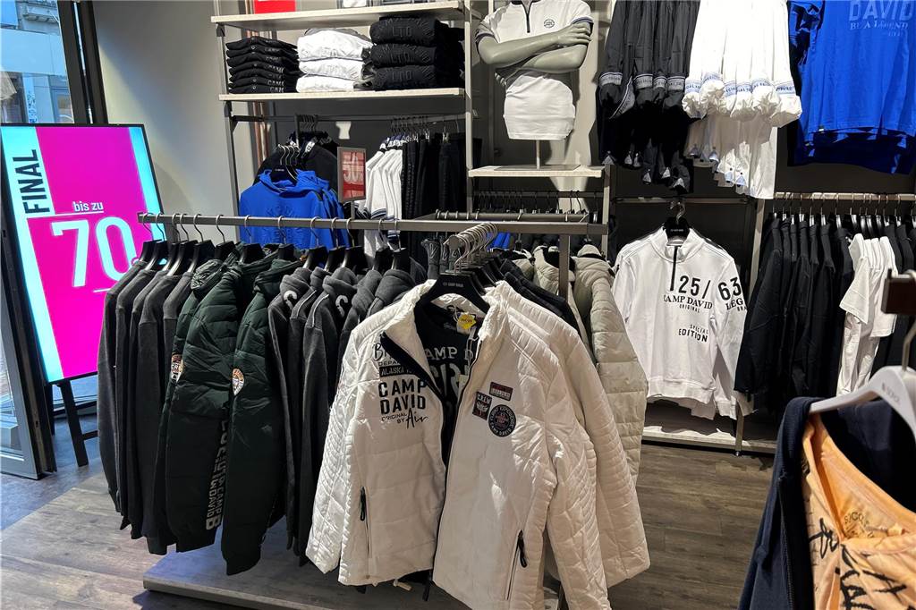 Camp-David-Store eröffnet: Marke trägt auch Pop-Titan Dieter Bohlen Blick in den "Camp David" Laden in Lünen. Die Kleidung ist überwiegend weiß, schwarz und blau.