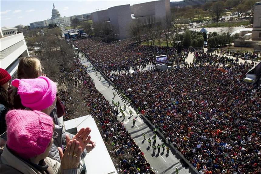 Beobachter schauen von einem Balkon auf die Menschenmassen, die beim „Marsch für unsere Leben“ in Washington gegen Waffengewalt demonstrieren. Foto: Jose Luis Magana/AP