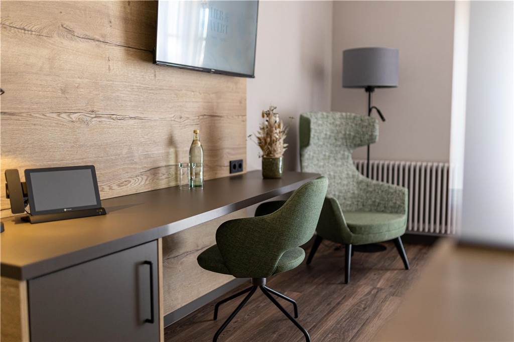 Hotel ist eröffnet: Lieb & Wert zeigt die Liebe zum Detail Bequem und heimelig: Der Sessel am Arbeitsplatz im Hotelzimmer macht die Arbeit zum Kinderspiel.