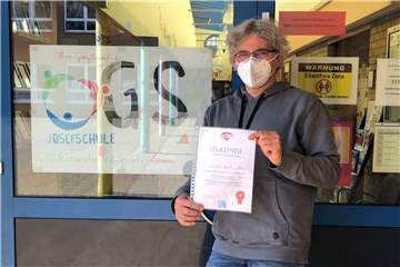 Bernd Elkemann, Koordinator der OGS an der Josefschule in Ahaus, hält eine Corona-Held-Urkunde in seinen Händen. Eingetragen hat er das OGS-Team.