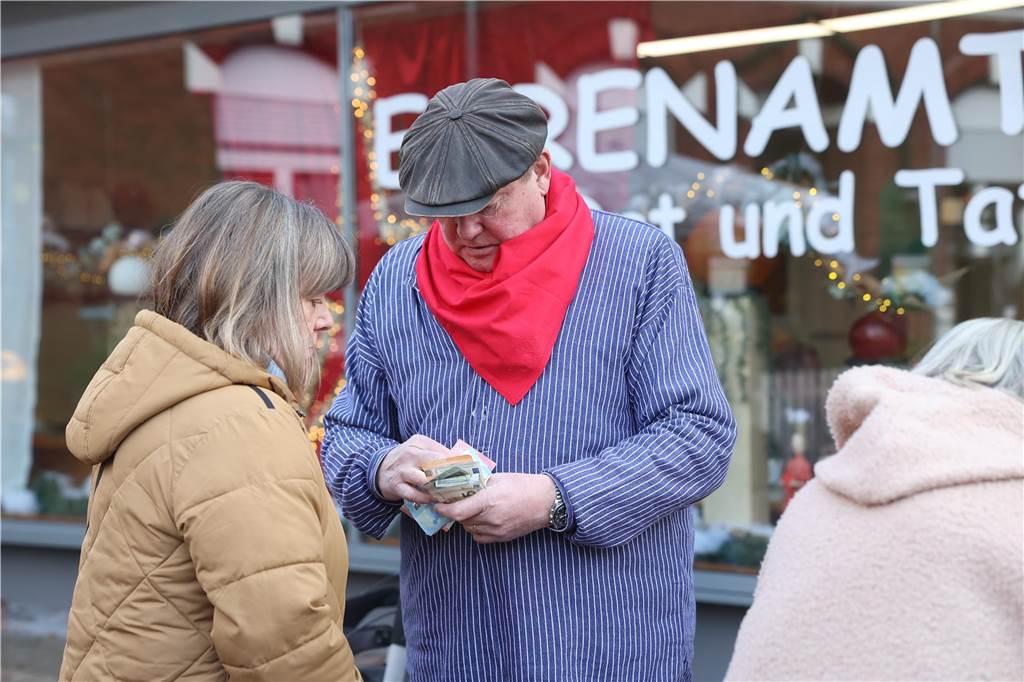 Adventsmarkt: Drei stimmungsvolle Tage und ein lustiger Höhepunkt Bernd-Hubert Baumeister zählte den Erlös, den der Bürgermeister mit den Fotos erzielt hat. Am Ende hatte Thomas Orlowski genau einen Euro weniger erzielt als Pfarrer Claus Themann.