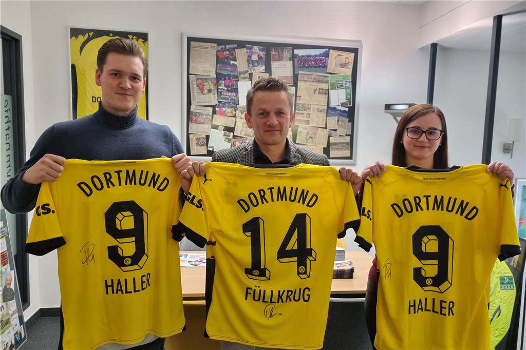 Benefizspiel mit BVB-Frauen: Frank Spotke rechnet mit 30.000 Euro plus X Drei Personen präsentierten BVB-Trikots.