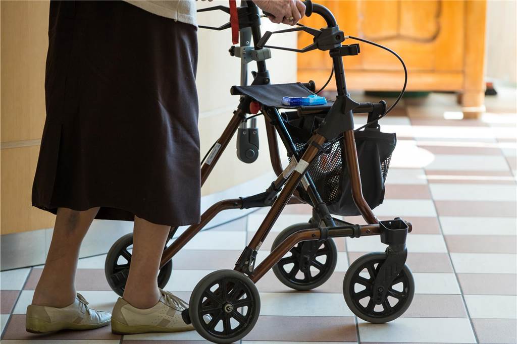 Heiligabend allein verbringen? Milan Gutkowski (42) lädt einsame Menschen ein Die Beine einer älteren Frau, die mit einem Rollator durch eine Wohnung läuft.