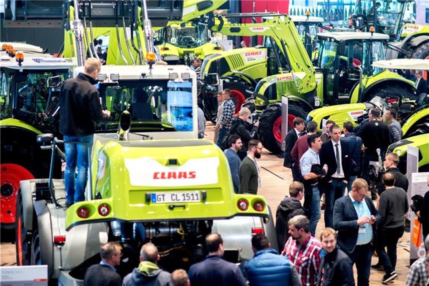Claas profitiert von Erholung in der Landwirtschaft Besucher betrachten auf Agritechnica verschiedene Traktoren. Foto: Hauke-Christian Dittrich/Archiv
