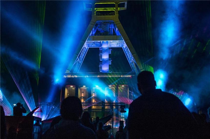 Besucher verfolgen in der Nacht vor dem Deutschen Bergbau Museum eine Laser-Show. Foto: Bernd Thissen/Archiv