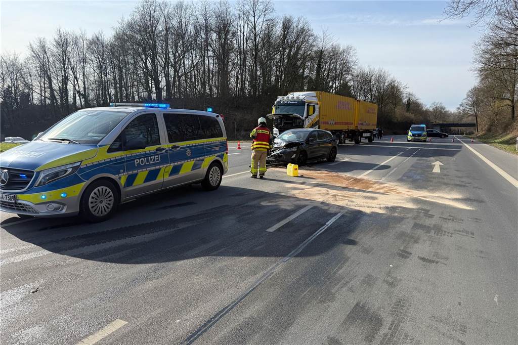Zusammenprall verursacht hohen Schaden und Verkehrsbehinderungen Ein Polizeiwagen, ein Unfallauto und ein Lkw stehen auf einer Straße.