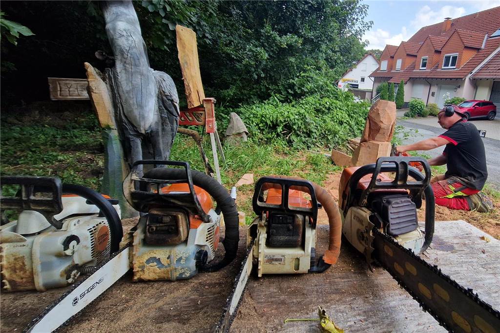 Eine Eule in nur 30 Minuten: Kai Mathias macht Kettensägen-Kunst Kettensägen-Künstler Kai Mathias aus Westhofen bei der Arbeit an einer Eule. Im Vordergrund liegen verschiedene Kettensägen.